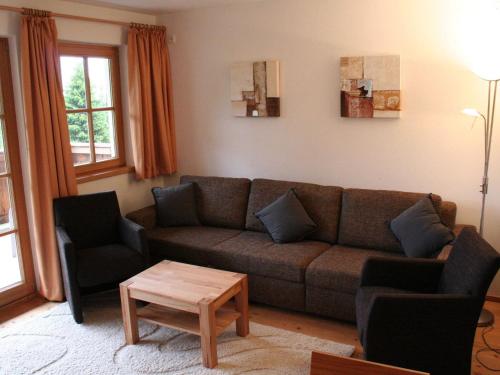 平茨高谷地霍勒尔斯巴赫Apartment with Sauna near Ski Slopes in Mittersill的客厅配有沙发、两把椅子和一张桌子
