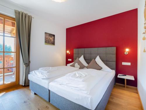 平茨高谷地霍勒尔斯巴赫18号全景木屋公寓的一间卧室设有一张红色墙壁的大床