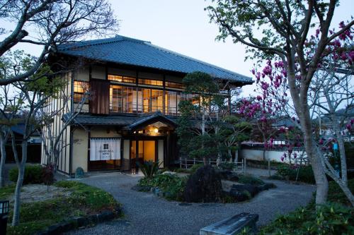 大洲NIPPONIA HOTEL Ozu Castle Town的一座拥有很多窗户和树木的建筑