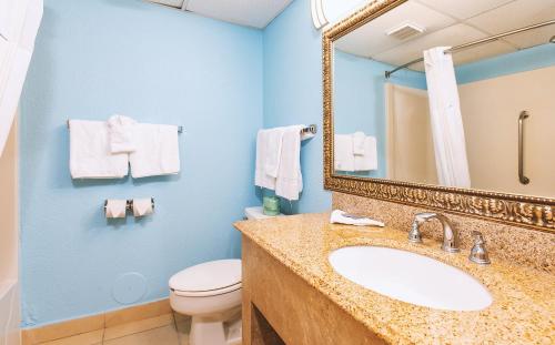 威奇托Sky-Palace Inn & Suites Wichita East的一间带水槽、卫生间和镜子的浴室