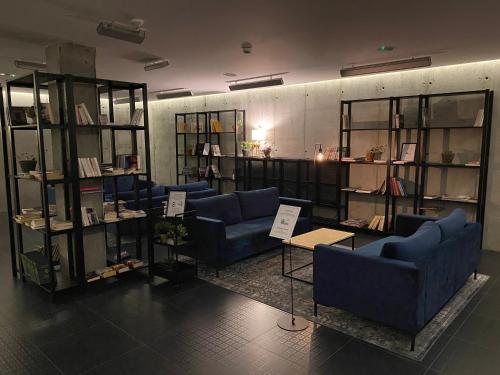 格丁尼亚Green Loft Gdynia的一间设有蓝色沙发和书架的房间