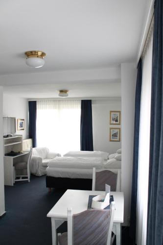 明斯特温索斯特酒店的酒店客房带两张床和一张桌子以及椅子。