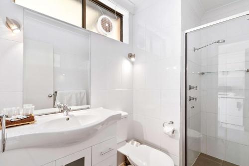 达博达博国际品质酒店的白色的浴室设有水槽和淋浴。