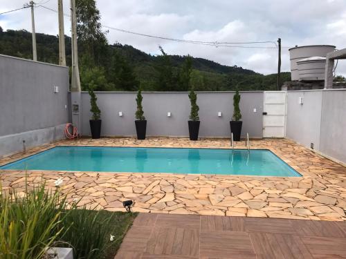 塞拉内格拉tranquilidade的庭院内种植了盆栽植物的游泳池