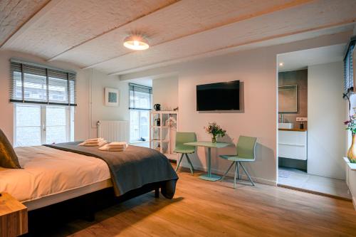 马斯特里赫特B&B Gracht 62的一间卧室配有一张床和一张桌子及椅子