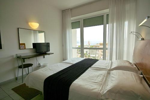 拉帕洛阿普罗多酒店的一间卧室配有一张床、一张书桌和一个窗户。
