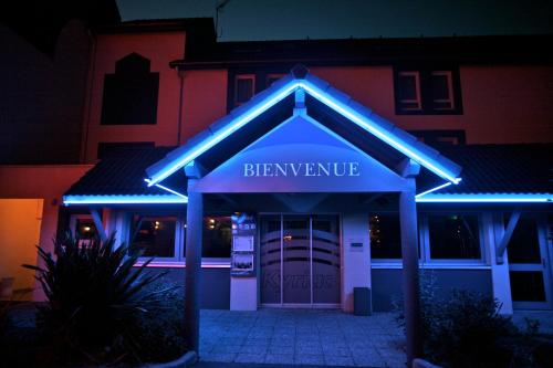 特赫格欧基里亚德圣布里尔克特雷格酒店的一座拥有蓝色灯光的啤酒厂入口的建筑