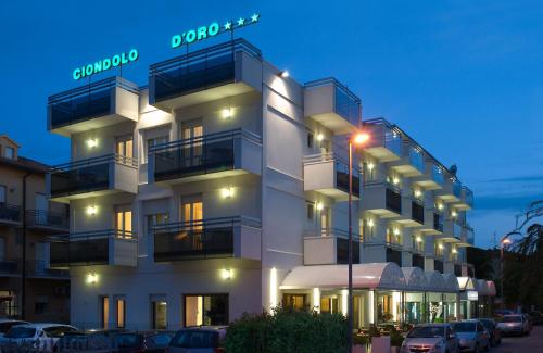 里米尼雄道罗多络酒店的一座大型白色建筑,设有阳台和停车场