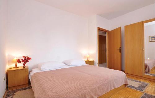 扎达尔米哈诺维卡4号公寓的一间卧室配有一张大床,设有两个床头柜和两盏灯