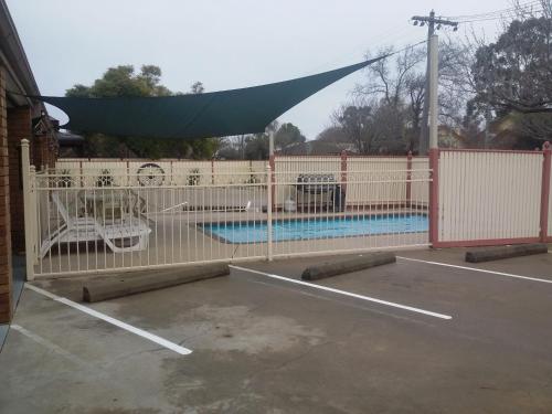 谢珀顿SHEPPARTON MOTOR INN Tudor House Motel的后面设有游泳池的白色围栏