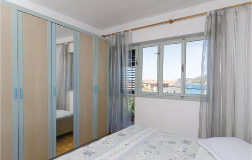 尼亚卢卡Nice Apartment In Vela Luka With Wifi的一间卧室设有一张床和一个大窗户