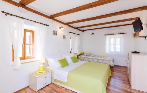 斯拉诺Cozy Home In Slano With Wifi的一间白色的卧室,配有绿色的床和电视