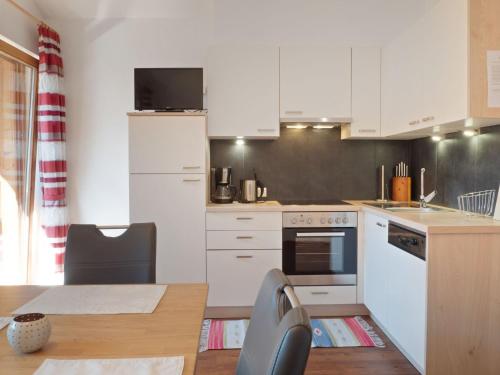 菲根Lovely Apartment with Terrace in F genberg的小厨房配有白色橱柜、桌子和桌布