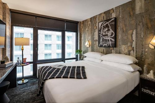 纽约The FIDI Hotel的卧室设有一张白色大床和大窗户