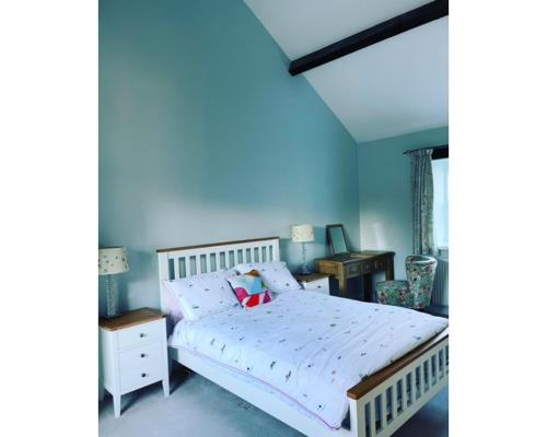 里彭Swallow Cottage的卧室配有白色的床和书桌