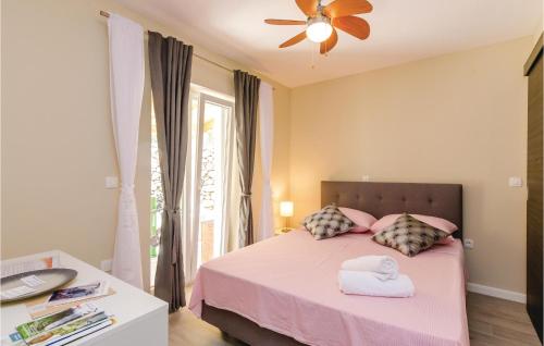 格鲁达Beautiful Home In Gruda With Kitchen的一间卧室配有粉红色的床和2条毛巾