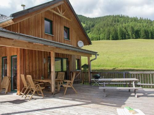 上陶恩Chalet in Hohentauern Styria with sauna的木屋在庭院设有野餐桌和椅子