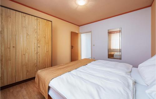 Pelegrin1 Bedroom Pet Friendly Apartment In Duba的卧室配有白色的床和木制橱柜。