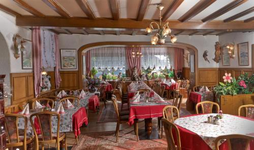 Kleinmaischeid麦切霍夫旅馆的一间带桌椅和吊灯的用餐室