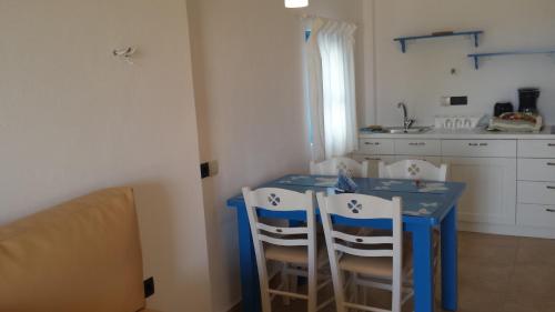 德里奥斯埃皮尼奥酒店的厨房配有蓝色的桌子和白色的椅子