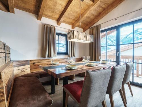 皮森多夫Luxurious holiday home in Piesendorf with sauna的一间带木桌和椅子的用餐室