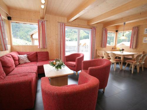 上陶恩四叶草度假屋的客厅配有红色的沙发、椅子和桌子
