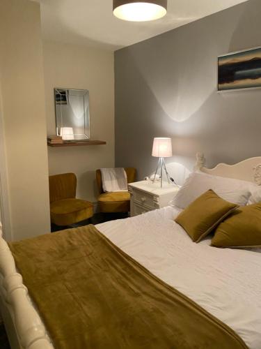 法尔卡拉The Strand Guest House的一间卧室配有一张床、一张桌子和一把椅子