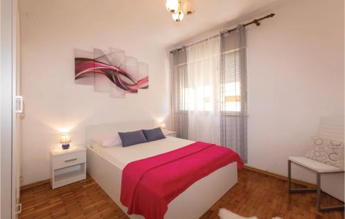 扎达尔Beautiful Apartment In Zadar With Outdoor Swimming Pool的一间卧室配有一张带红色毯子的床