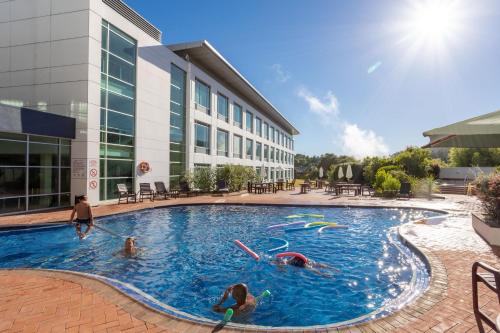 罗托鲁瓦Rydges Rotorua的一群人在一座建筑物的游泳池里玩耍