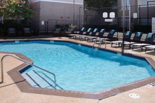达拉斯Sonesta ES Suites Dallas Medical Market Center的酒店设有一个大型游泳池,配有椅子