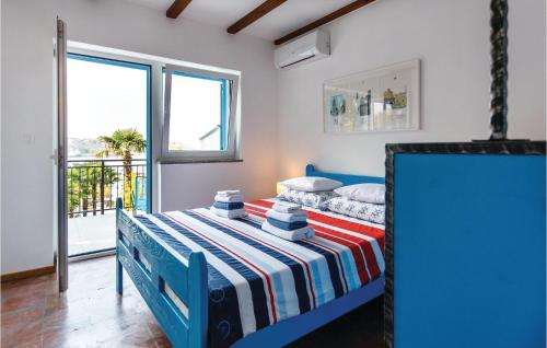 奥米沙利Awesome Home In Omisalj With 4 Bedrooms, Wifi And Outdoor Swimming Pool的一间卧室配有一张蓝色的床和条纹毯子