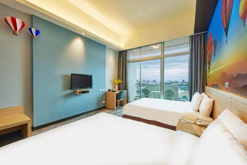 台东娜路湾会馆的一间酒店客房,设有两张床和电视