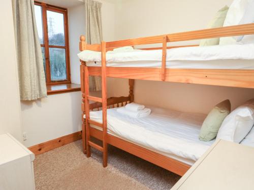 皮特洛赫里MacKintosh的一间卧室设有两张双层床和一扇窗户。