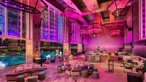 吉隆坡Tropicana The Residences KLCC CozeeStay的酒店大堂设有游泳池和紫色照明