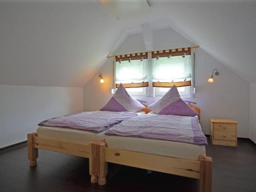 格拉斯许特Spacious holiday home in Sauerland with terrace的一间卧室配有一张带紫色床单的床和窗户。