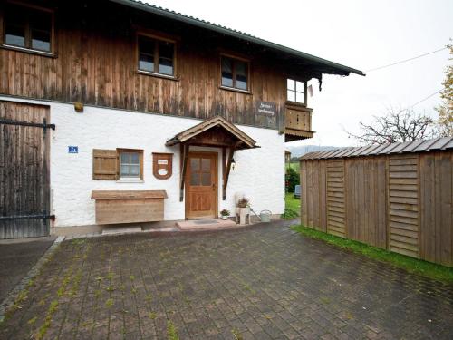 施泰因加登Spacious apartment near the ski area的白色的建筑,设有木制谷仓和车库