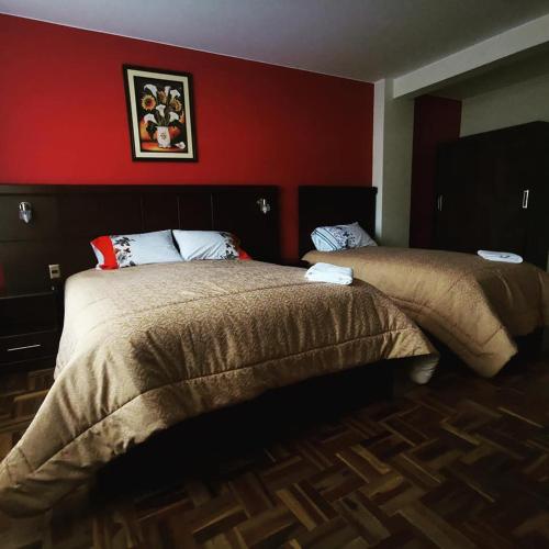 拉巴斯Hostal Belisario的一间卧室设有两张床和红色的墙壁
