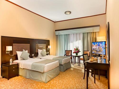 迪拜切尔西花园公寓酒店的酒店客房配有两张床和一张书桌