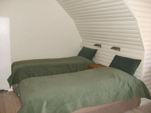 维堡Nattely I Viborg By的白色墙壁的客房内设有两张绿色的床