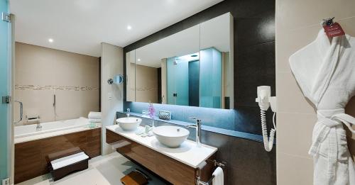 迪拜卡尔顿市中心酒店（原迪拜华威酒店）的一间带两个盥洗盆和大镜子的浴室