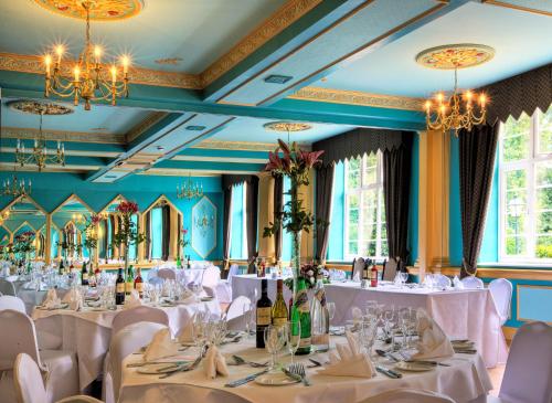 坎特伯雷贝斯特韦斯特阿博特巴顿酒店的用餐室配有白色桌椅和吊灯。