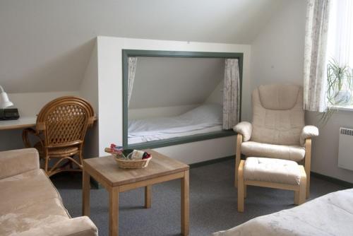 Fårup普尔胡斯克罗宾馆的客厅配有床、椅子和镜子