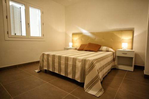 库斯托纳奇紫海度假屋的一间卧室配有带2个床头柜和1扇窗户的床