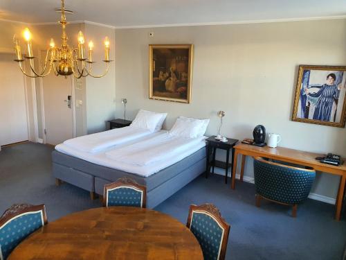 利勒哈默尔布雷塞斯第一酒店的酒店客房配有床、桌子和桌子。