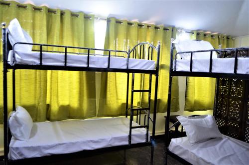 SirodaMarias house的配有黄色窗帘的客房内的两张双层床
