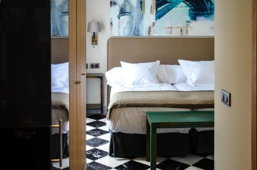 塞维利亚赛维拉阿圭拉斯5号套房酒店的卧室配有一张床和一张桌子