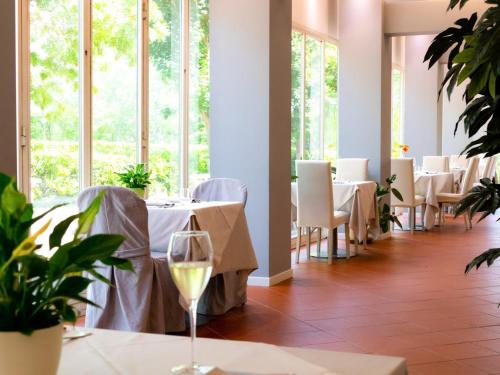 圣彼得罗-泰尔梅堡卡萨罗爱米迪克瑞斯酒店的餐厅设有白色的桌椅和窗户。