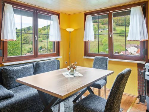 LangenbachHoliday home in Thuringia near the lake的一间带桌椅和窗户的用餐室