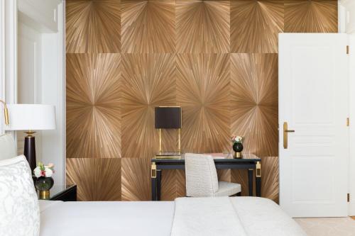 日内瓦The Woodward - an Oetker Collection Hotel的一间卧室配有一张床、一张桌子和一面墙