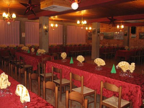 伊索拉德尔格兰萨索Hotel Casale的宴会厅配有桌椅和红色桌布